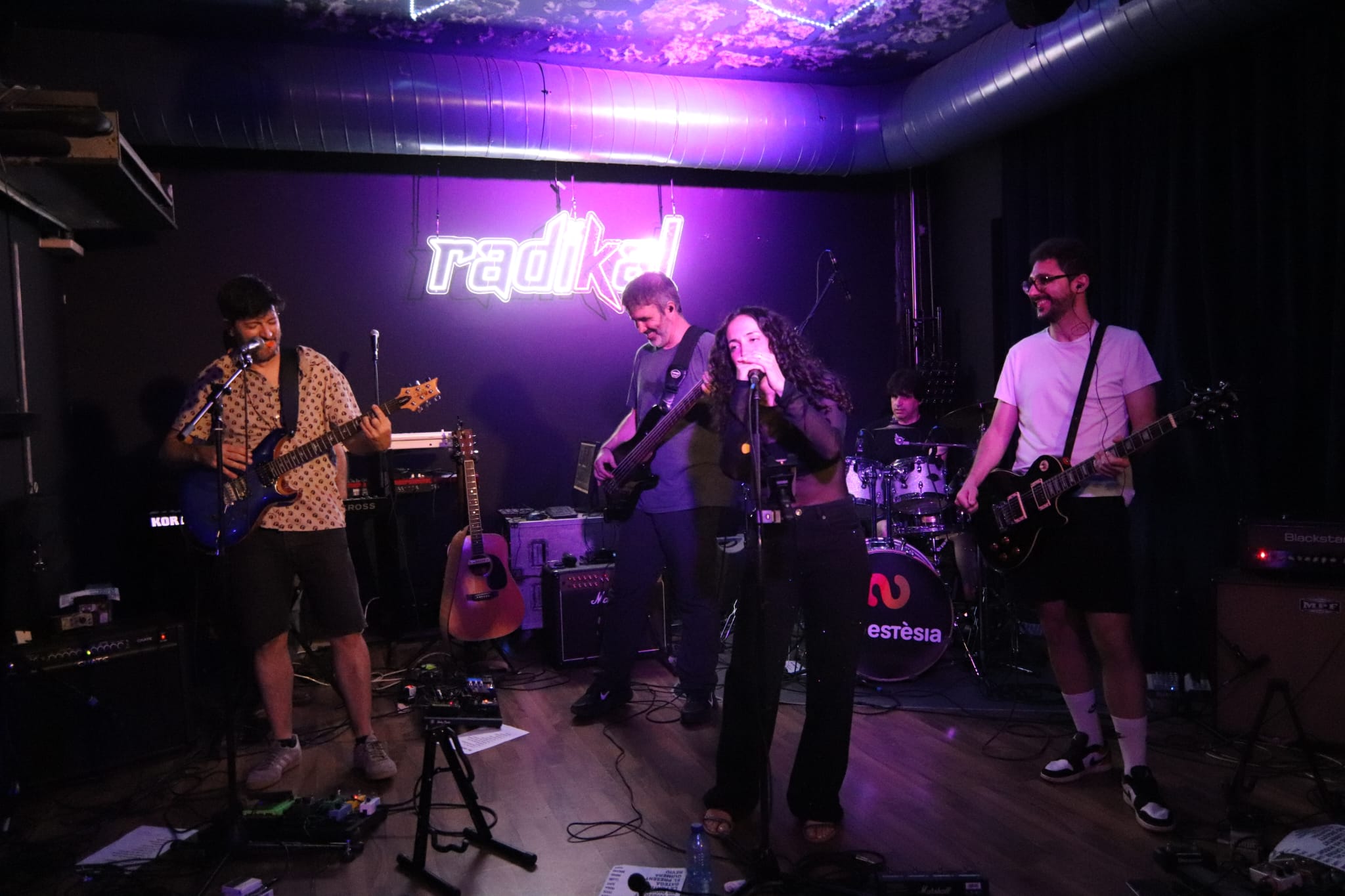 Lluís, Bruno, Rosa, Marcel i Xavi tocant sota el rètol de neó de la Sala Radikal